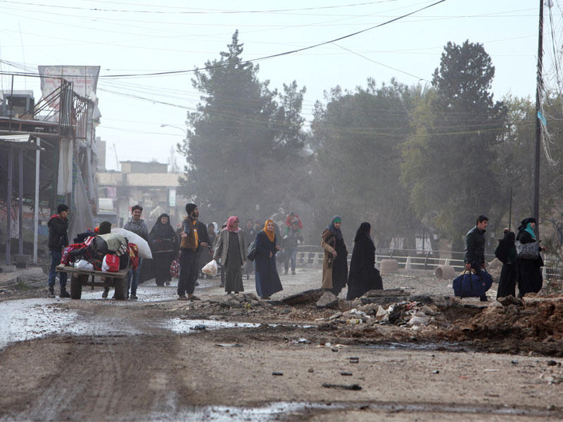 عدد من النازحين في حي الزهور بالموصل أمس (رويترز)