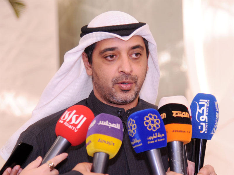 وزير الدولة لشؤون مجلس الوزراء محمد العبدالله  أثناء الحديث لوسائل الإعلام في مجلس الأمة اليوم