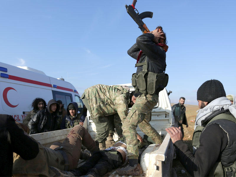 مقاتل في الجيش الحر يبكي شقيقه الذي قتل بهجوم على «داعش» في بلدة قباسين أمسt(رويترز)