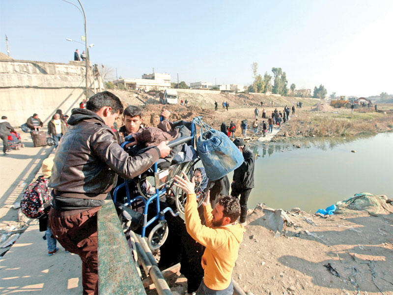 مدنيون عراقيون يحاولون عبور الجسر للخلاص من تنظيم داعش أمس الأول (رويترز)