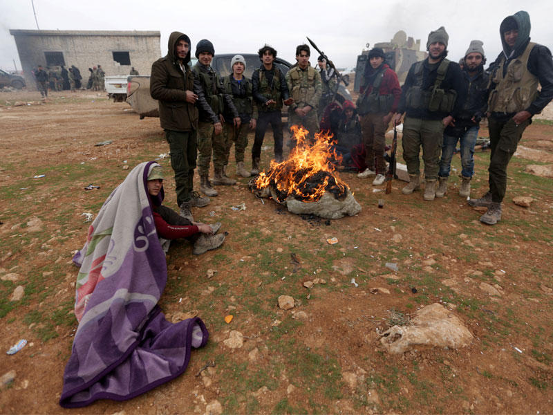 مقاتلون في الجيش الحر يجتمعون للتدفئة على مشارف مدينة الباب  (رويترز)n