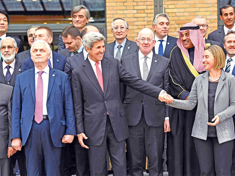 كيري ممازحاً وزيرة خارجية «الاتحاد الأوروبي» فريدريكا موغيريني قبل أخذ الصورة التذكارية لمؤتمر باريس أمسt(أ ف ب)