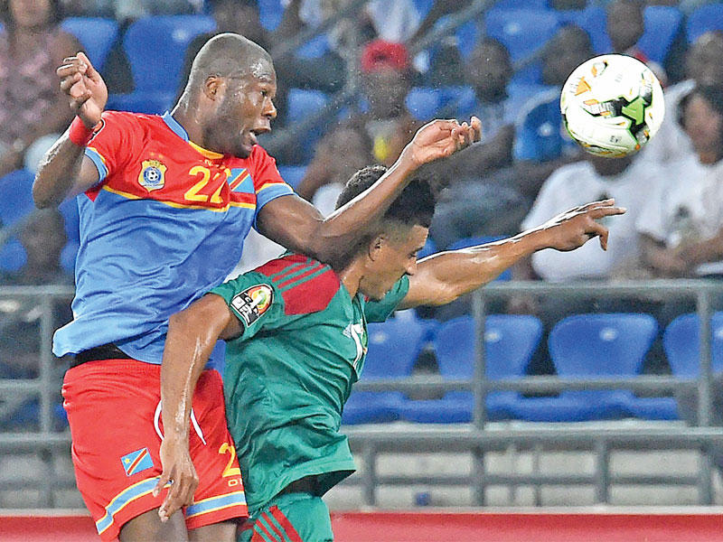 مدافع الكونغو مبيمبا في كرة مشتركة مع لاعب خط الوسط المغربي نبيل درار خلال المباراة (أ ف ب)n