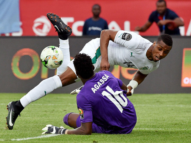 حارس مرمى توغو كوسي يعترض تسديدة مهاجم ساحل العاج جوناثان على المرمى. (أ ف ب )