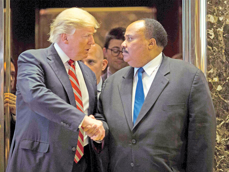 ترامب يصافح ابن مارتن لوثر كينغ في ترامب تاور في نيويورك أمس الأول t(أ ف ب)