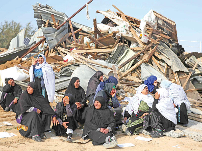 بدويات أمام منزل مهدم في النقب أمس (أ ف ب)