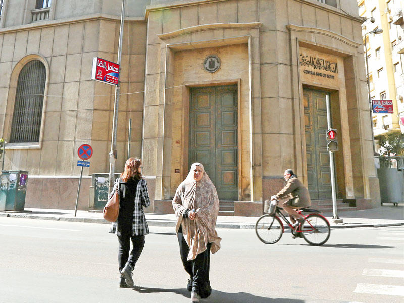 مصريون في محيط مقر البنك المركزي وسط القاهرة أمس الأول           (رويترز)