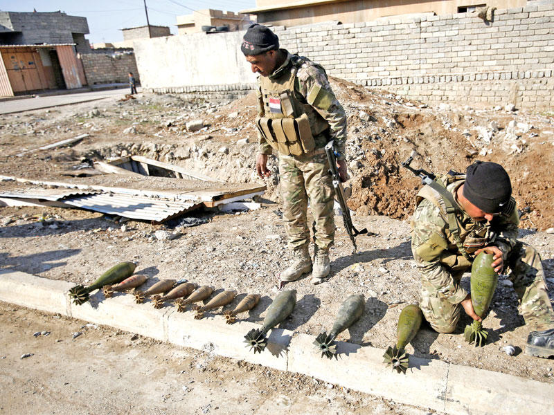 جنديان عراقيان يحصيان أسلحة تركها تنظيم «داعش» في قضاء تلكيف أمس t(رويترز)n