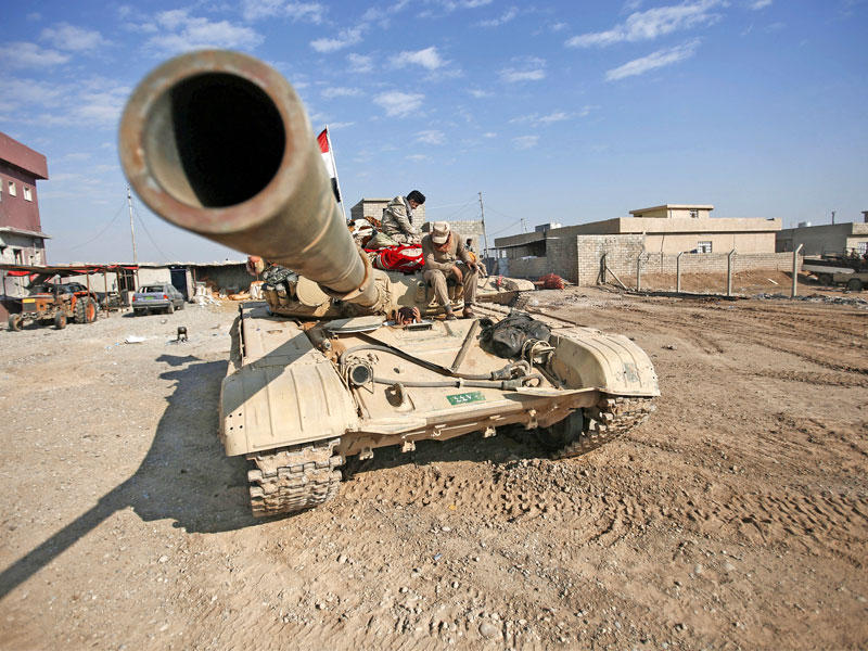 جنديان في استراحة على دبابة بمنطقة تلكيف شمال الموصل أمس (رويترز)