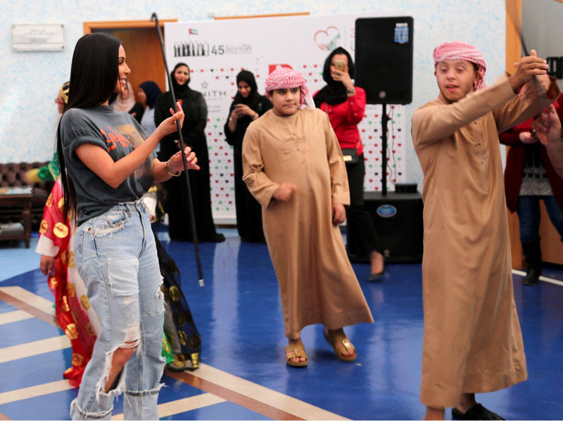 كيم كارداشيان اثناء الرقص مع الأطفال المعوقين خلال زيارتها لمركز راشد