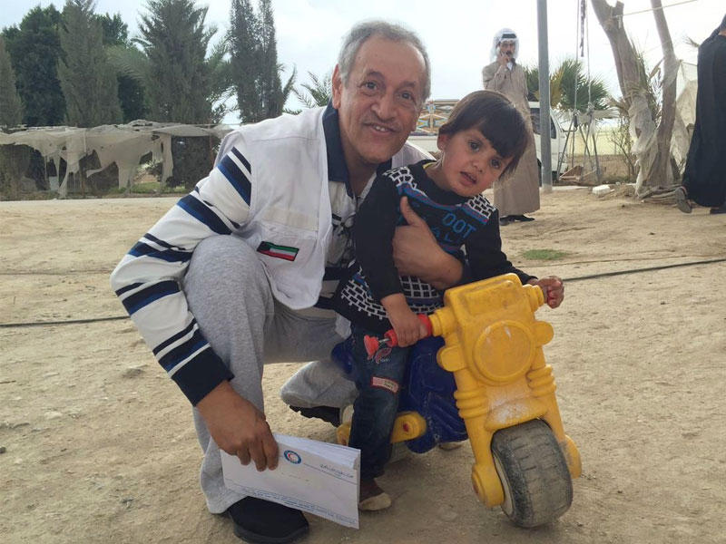  الحساوي مع أحد الأطفال السوريين اللاجئين