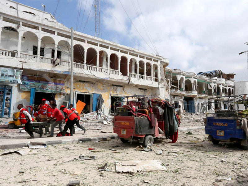 ارشيفية |عمال الانقاذ يحملون رجلا مصابا من مكان انفجار أمام فندق الداية في العاصمة الصومالية مقديشو .