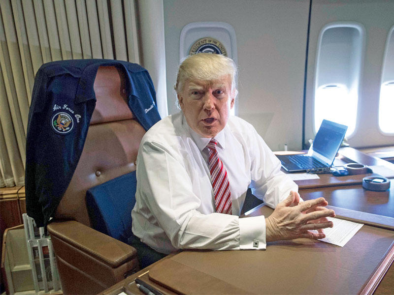 ترامب على مكتبه بالطائرة الرئاسية إير فورس ون أمس (أ ف ب)n