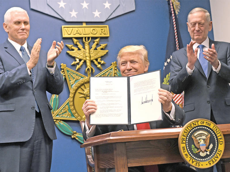 ترامب يرفع قرارا تنفيذيا لتطوير القوات المسلحة بعد توقيعه مساء أمس الأول بحضور وزير الدفاع جيمس ماتيس في واشنطن (أ ف ب)