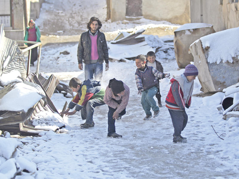 أطفال سوريون يلهون بالثلوج في بلدة الراعي في ريف حلب شمال سورية أمس   (رويترز)