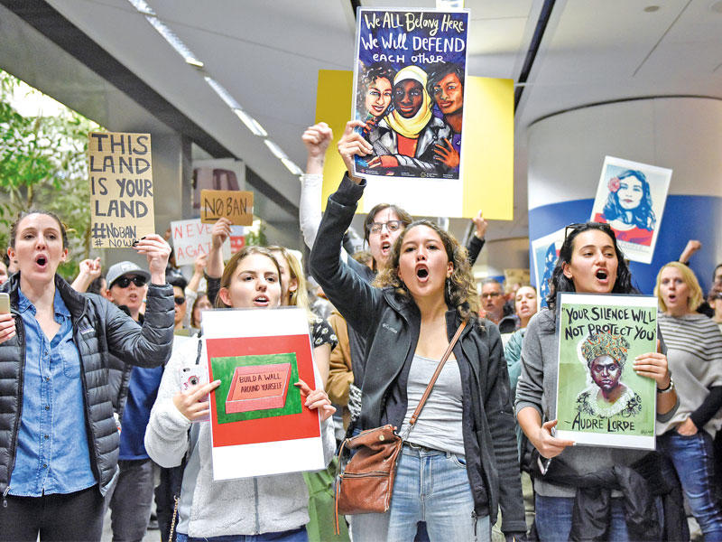 أميركيات يتظاهرن ضد حظر ترامب في مطار سان فرانسيسكو أمس الأول (رويترز)