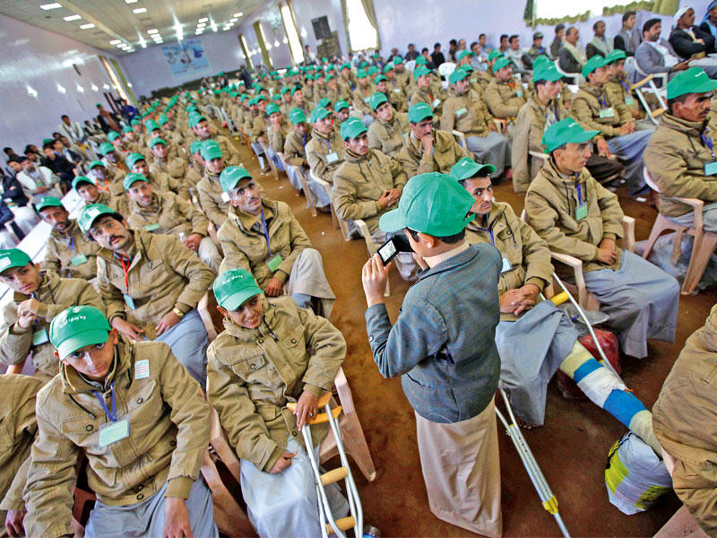 طفل يلتقط صورة خلال تجمع لمصابين من عناصر الميليشيات الحوثية في صنعاء أمس (رويترز)