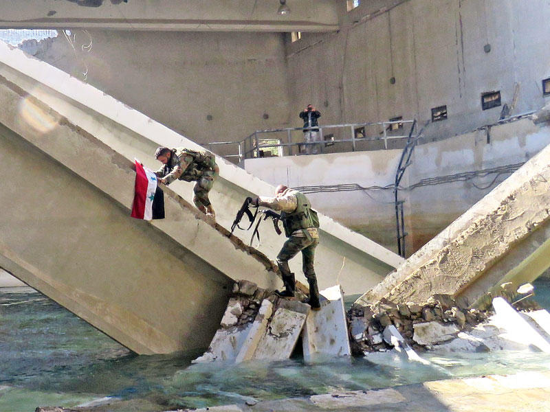 جنديان يجهدان لرفع العلم في محطة ضخ المياه بعين الفيجة أمسt(أ ف ب)