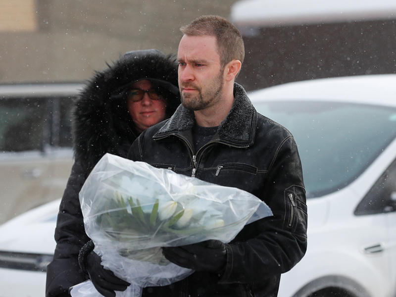 مواطنون كنديون يضعون الزهور في موقع الحادث في مقاطعة كيبك الكندية