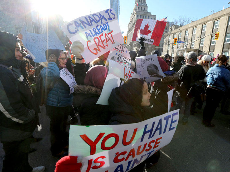 كنديون يتظاهرون ضد حظر ترامب أمام القنصلية الأميركية في تورنتو أمس (رويترز)