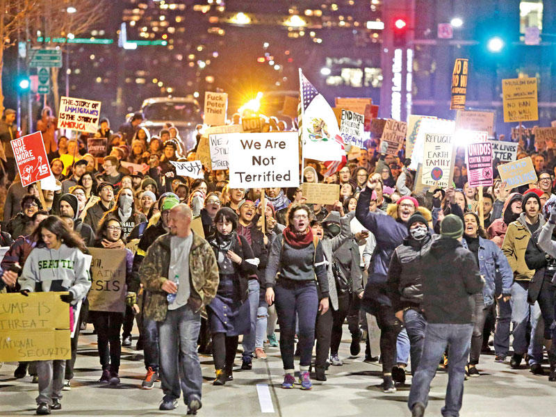 متظاهرون داعمون للمهاجرين في مدينة سياتل بولاية واشنطن أمس الأول (أ ف ب)