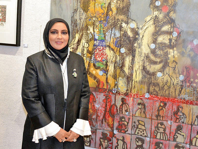 البدر أمام أحد أعمالها الفنيةn