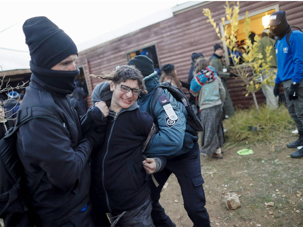 قوات الأمن الإسرائيلية تحمل المستوطنين بعيدا