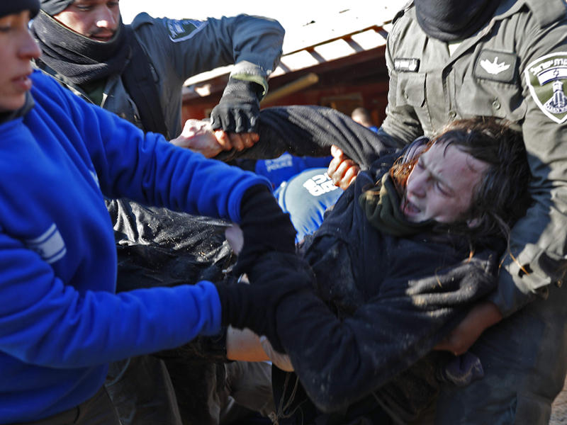 الشرطة الاسرائيلية تحمل مستوطن إسرائيلي في اليوم الثاني من عملية لطرد المحتلين المتشددين ومؤيديهم من موقع استيطاني بالضفة الغربية