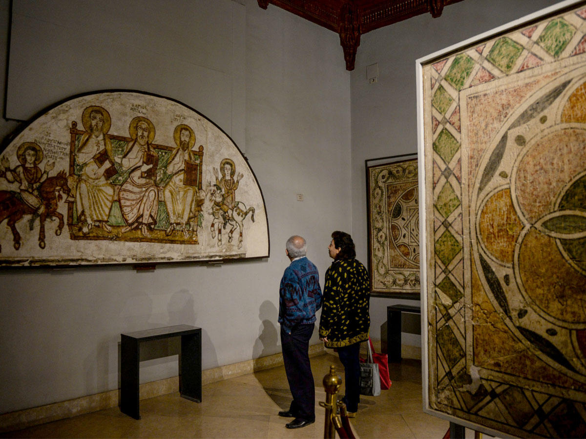 زائران يلقيان نظرة على أيقونات داخل المتحف القبطي بمصر القديمة أمس (إي بي أيه)