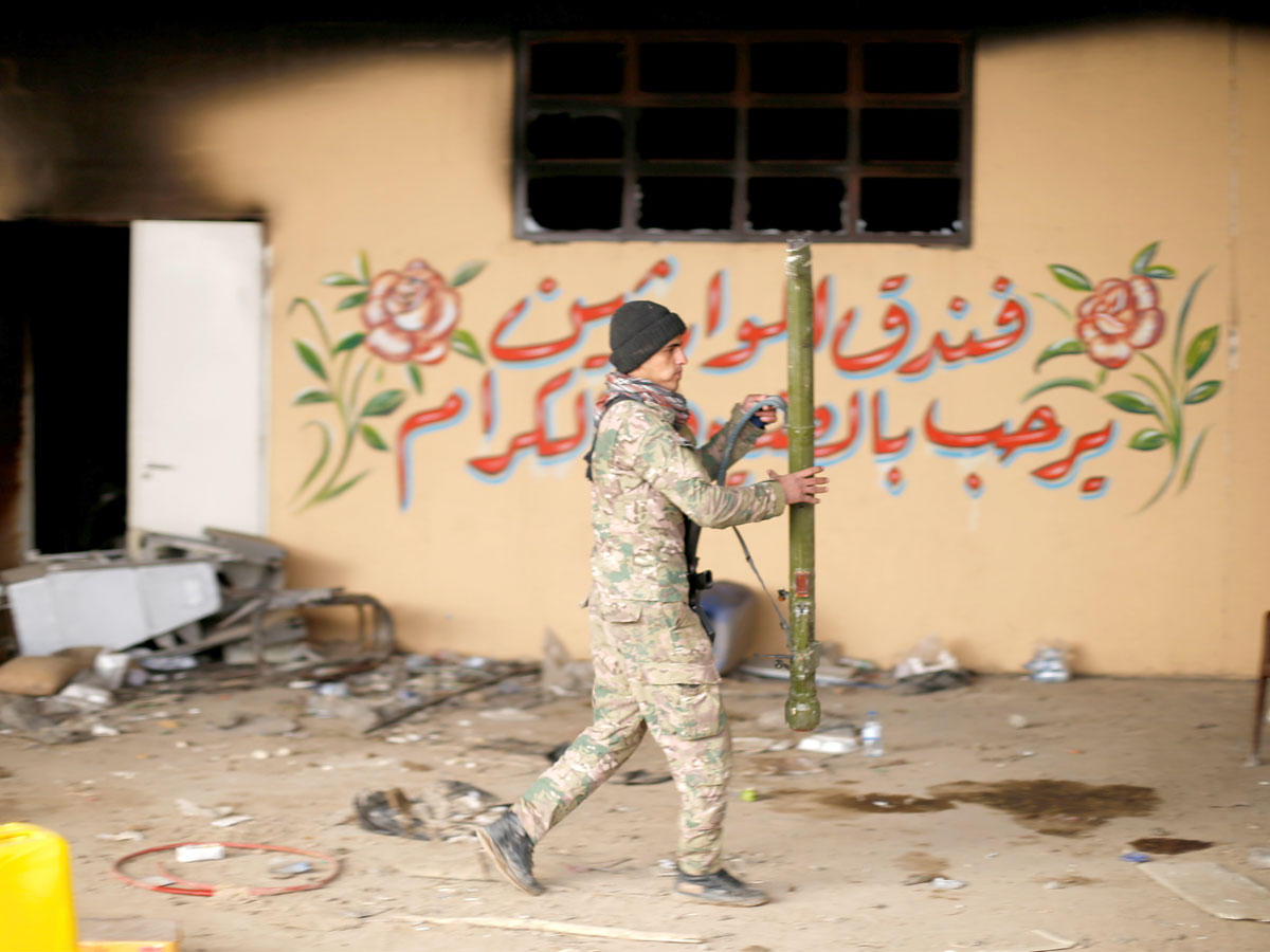 جندي عراقي يمشي بالسلاح أمام فندق أوبروي في مدينة الموصل