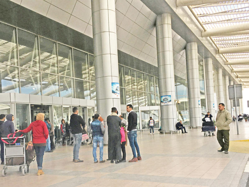 مصريون خارج مطار القاهرة أمس (رويترز)