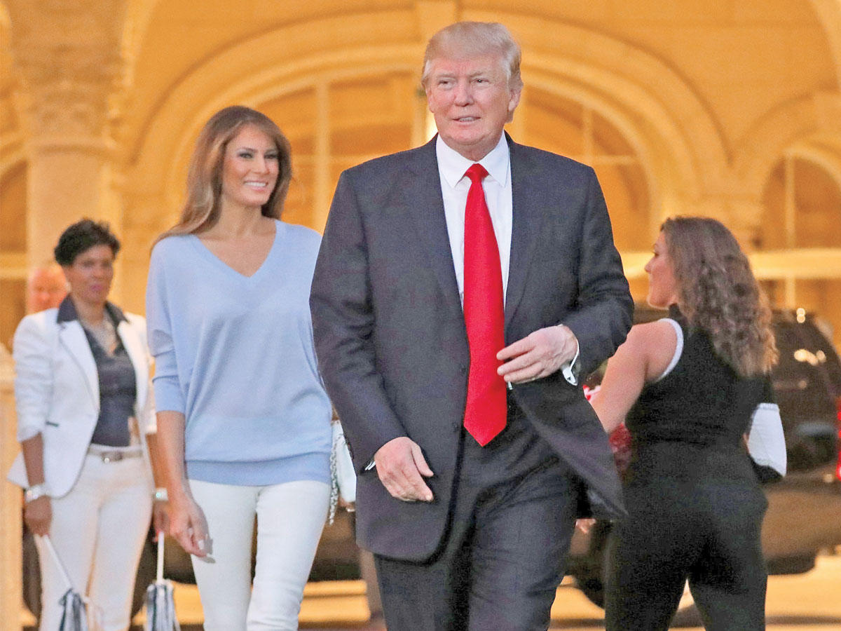 ترامب وزوجته ميلانيا في نادي ترامب إنترناشونال للغولف بولاية فلوريدا أمس الأول ( رويترز)