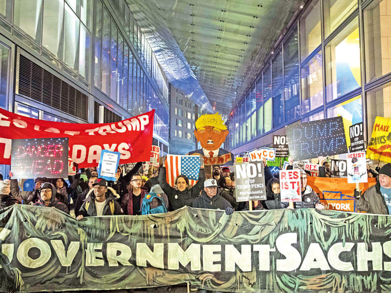 معارضون لترامب يتظاهرون خارج مبنى غولدمان ساكس في مانهاتن بمدينة نيويورك أمس الأول    (أ ف ب)
