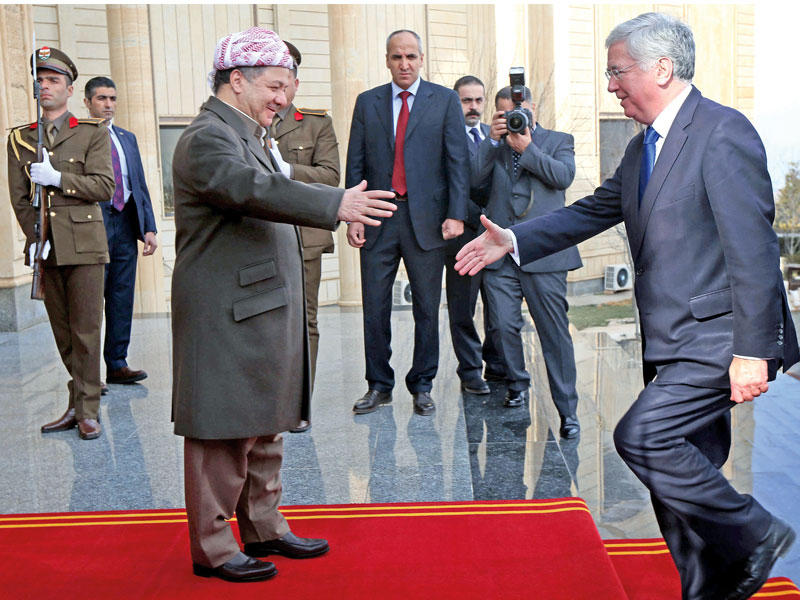رئيس إقليم كردستان العراق مسعود بارزاني مستقبلا وزير الدفاع البريطاني مايكل فالون لدى وصوله إلى مدينة أربيل أمس (أ ف ب)