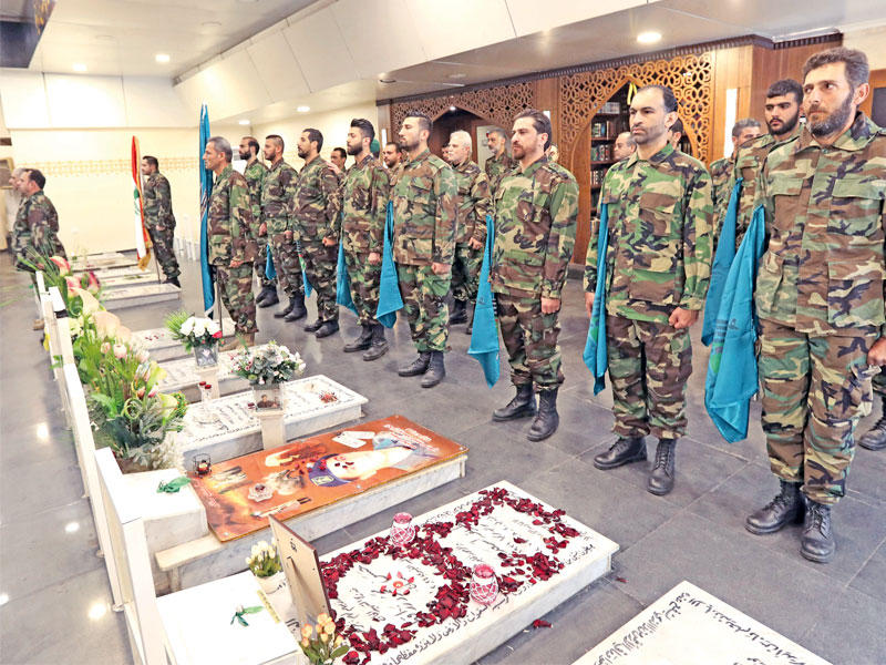 مقاتلون من حزب الله خلال احتفال بروضة الشهيدين بالضاحية الجنوبية أمس (أ ف ب)