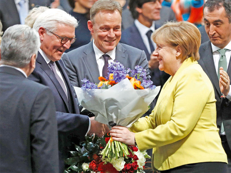 ميركل تهنئ شتاينماير بعد انتخابه رئيسا بمقر «البوندستاغ» في برلين أمس  (أ ف ب)