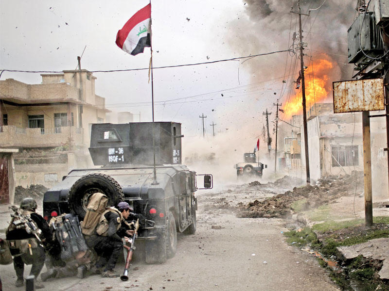 صورة وزعت أمس تعود إلى نوفمبر الماضي تظهر جنوداً عراقيين يختبئون بعد تعرضهم لعملية انتحارية في شرق الموصل (رويترز)