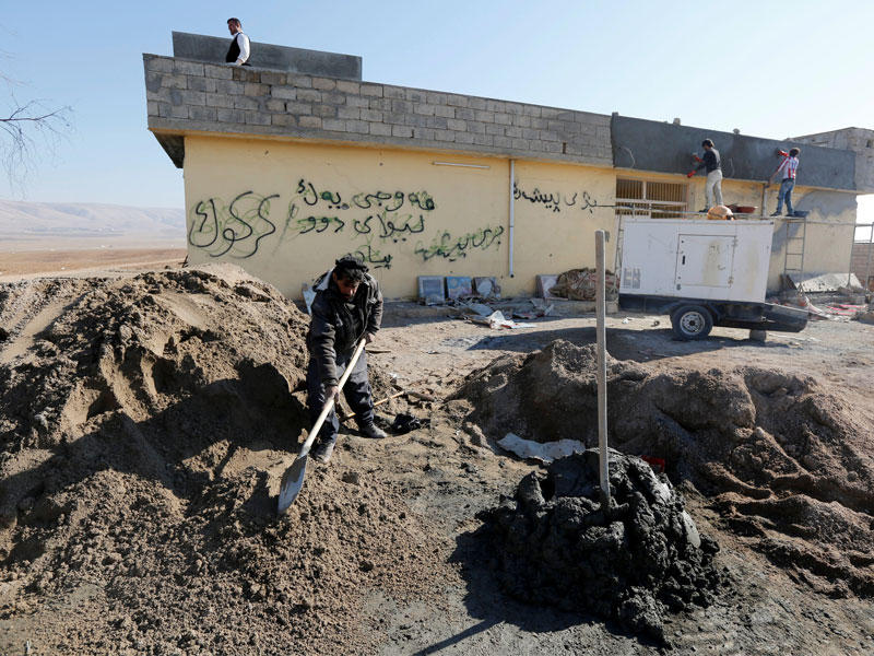 عامل يعمل على إصلاح منزل بعد تعرضه لاضرار خلال اشتباكات