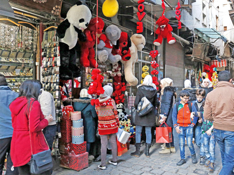 سوريون بسوق لبيع الهدايا وسط دمشق أمس الأول (إي بي أيه)