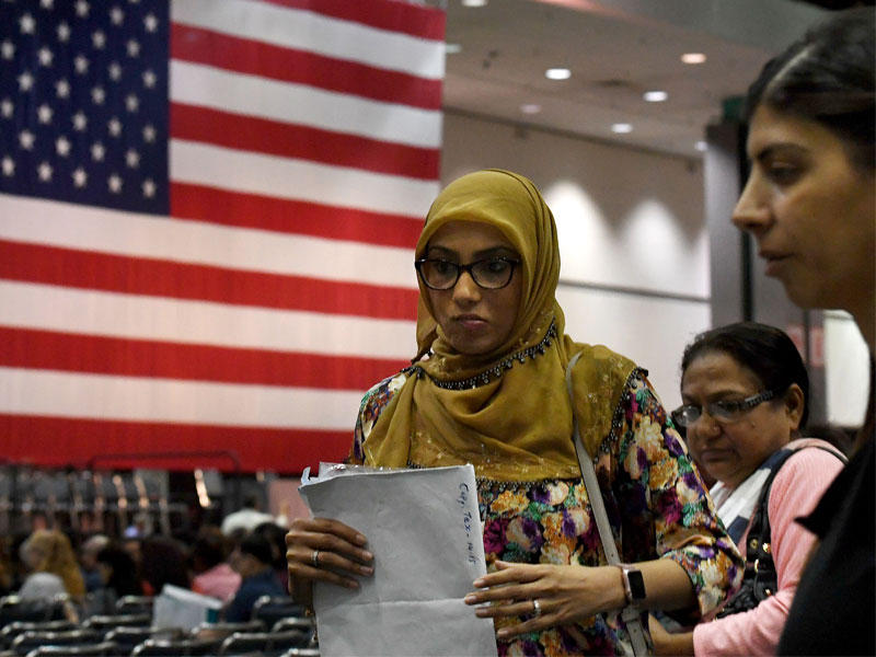 مهاجرة تدعى سحر تدلي بقسم الولاء للولايات المتحدة خلال احتفال لتجنيس مهاجرين في لوس أنجليس بولاية كاليفورنيا أمس الأول (أ ف ب)