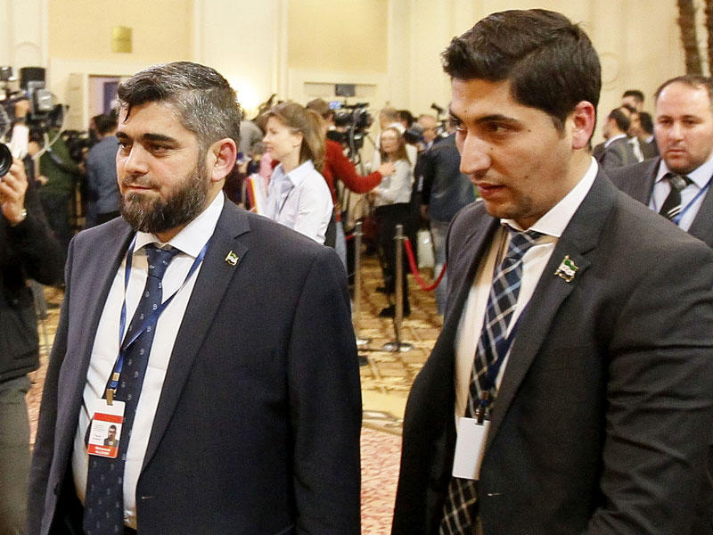 علوش لدى وصوله إلى قاعة المباحثات في آستانة أمس      (أ ف ب)