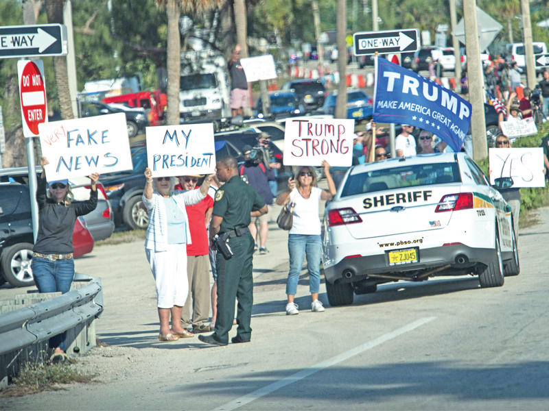 أنصار ترامب يستقبلون موكبه أمام مقر إقامته في بالم بيتش بولاية فلوريدا أمس الأول (أ ف ب)