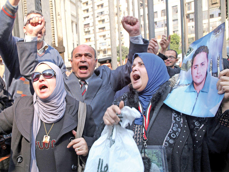 بعض الأهالي يحتفلون خارج قاعة محكمة عقب إصدار أحكام إدانة نهائية بالقضية المعروفة بـ«مجزرة استاد بورسعيد» وسط القاهرة أمس (إي بي أيه)