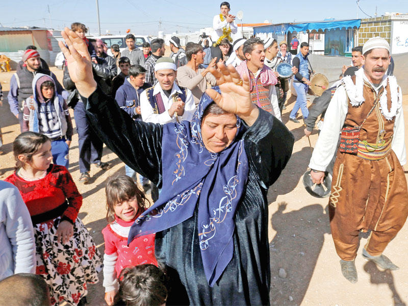 مواطنة سورية تتقدم زفة لاجئ في مخيم الزعتري بمدينة المفرق الأردنية أمسt(رويترز)