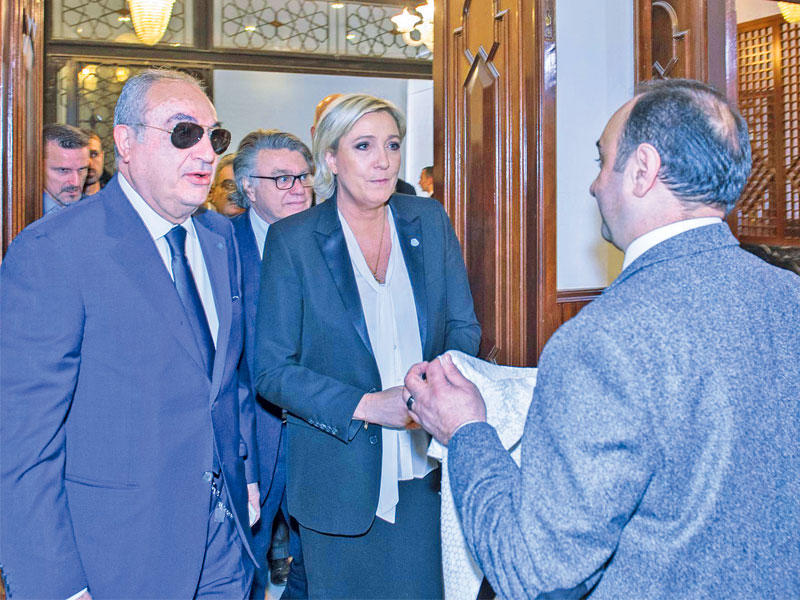 موظف بدار الفتوى يعرض على لوبن منديلاً في بيروت أمس