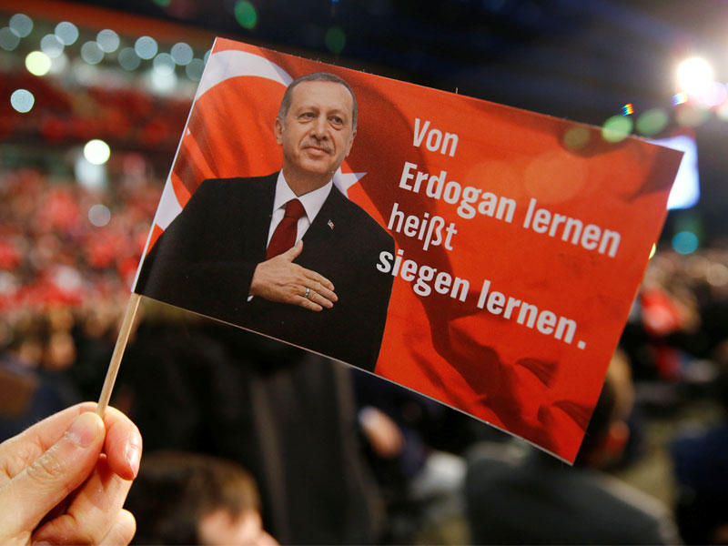 صورة أرشيفية رجل يحمل العلم يظهر الرئيس التركي رجب طيب اردوغان