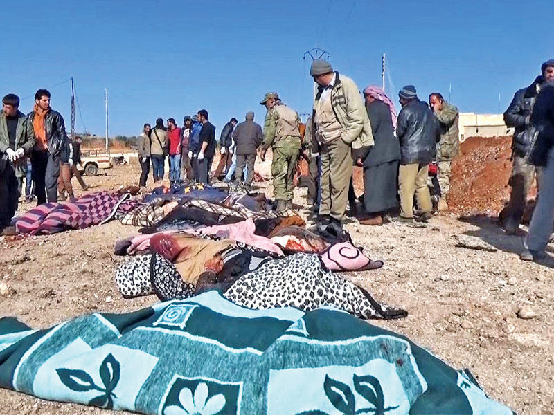 سوريون يتفقدون جثث ضحايا المجزرة في مدينة الباب أمس (أ ف ب)n