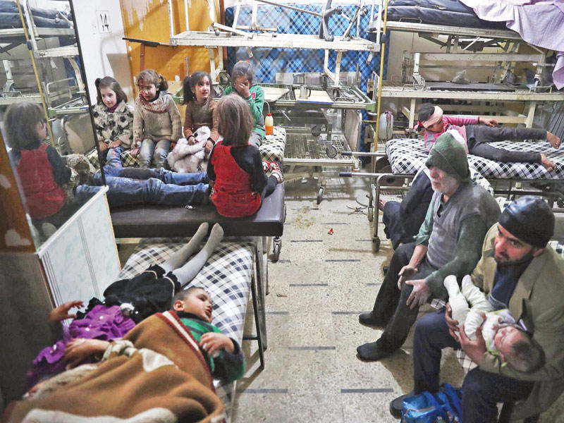 أطفال مصابون في غارة نظامية يحتمون مع ذويهم بمشفى ميداني في دوما أمس (أ ف ب)