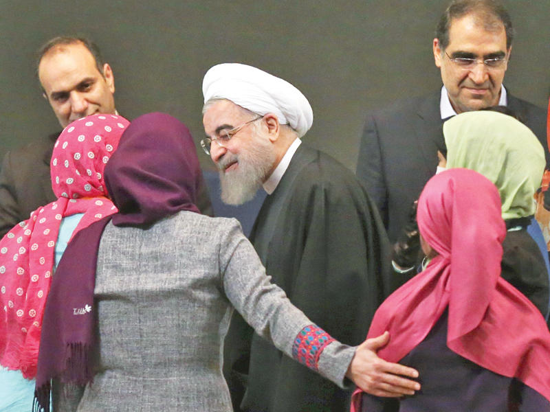 روحاني يحيي إيرانيات لدى حضوره فعالية في مركز الرازي للمؤتمرات بطهران أمس (إرنا)