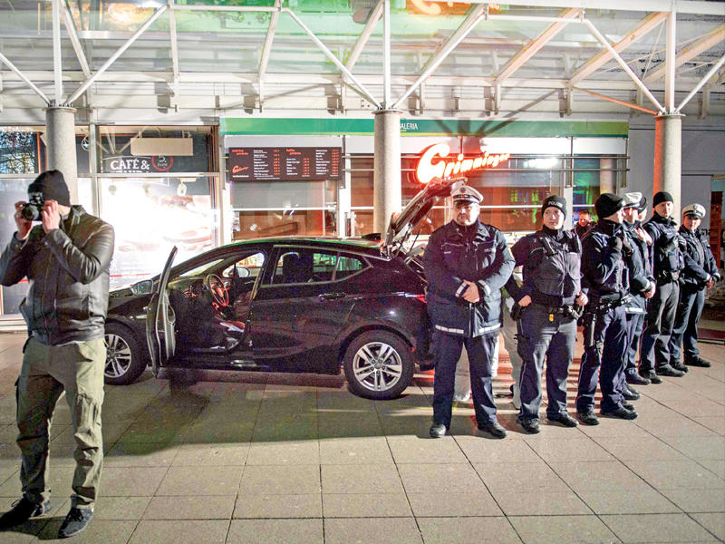 الشرطة الألمانية تطوق سيارة المشتبه به أمام مبنى الأعمال في هايدلبرغ     (أ ف ب)